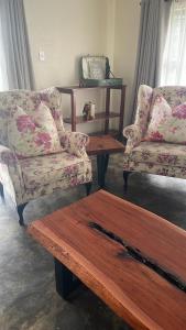 a living room with two chairs and a coffee table at Indaba tree lodge in Bulawayo +1 photo