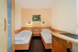 a small room with two beds and a desk at Haus Baden in Hagnau