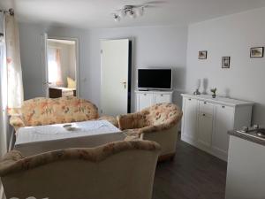a living room with two chairs and a bed at Ferienhaus Karger in Sagard