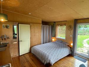 a bedroom with a bed in a room with a window at Chalet panoramique et moderne tout confort in Saizy