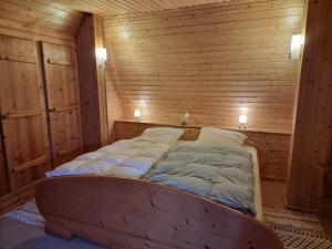 a bed in a wooden room with two lights at Reethus Mandy in Staphel