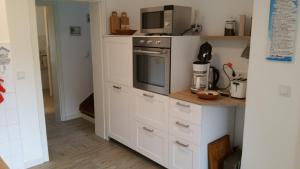 a kitchen with a microwave on top of a counter at Familienhaus Sonne in Mukran