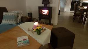 a candle on a table in a living room with a fireplace at Familienhaus Sonne in Mukran