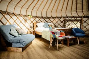 a yurt bedroom with a bed and a chair at Kelburn Yurts - Cockle in Fairlie