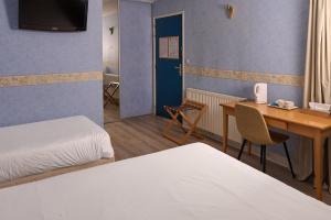 a hotel room with a bed and a desk and a table at Hôtel Restaurant Le Plat d'Etain in Brou +18 photos