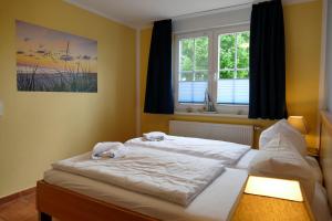 a bedroom with two beds and a window at Ferienwohnung Kranichglück in Neddesitz