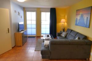 a living room with a couch and a tv at Ferienwohnung Kranichglück in Neddesitz