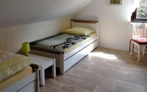 a small bedroom with a bed and a chair at Ferienwohnung Stockrose in Lohme