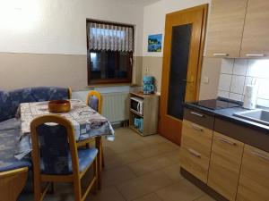 a kitchen with a table and a small table and a table and a kitchen at Ferienwohnung Boddennähe in Polchow