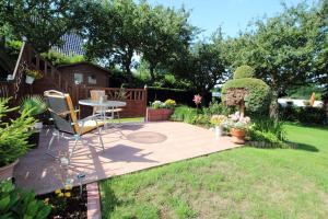 a patio with a table and chairs in a garden at Ferienwohnung Boddennähe in Polchow +1 photo