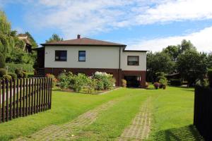 a house with a fence and a green yard at Ferienwohnung Boddennähe in Polchow