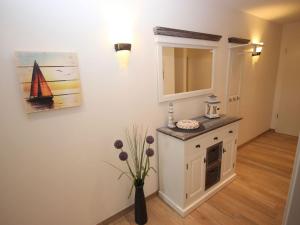 a kitchen with a cabinet and a vase of flowers at Villa Amelie App Seestern in Sassnitz