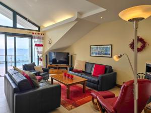 a living room with two couches and a tv at Villa Friede-Marie, Penthouse Lenea in Sassnitz