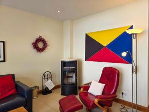 a living room with two chairs and a tv at Villa Friede-Marie, Penthouse Lenea in Sassnitz +15 photos