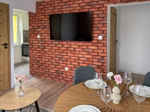 a dining room with two tables and a brick wall at Apartament Bałandy 32 in Oświęcim +14 photos