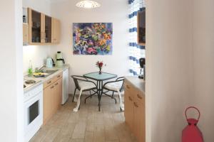 a small kitchen with a table and a painting on the wall at Ferienwohnung *Richi* in Sassnitz