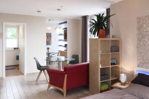 a living room with a red couch and a table at Ferienwohnung *Richi* in Sassnitz