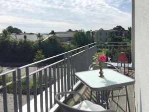 a table and chairs on a balcony with a vase of flowers at Ferienwohnung *Richi* in Sassnitz