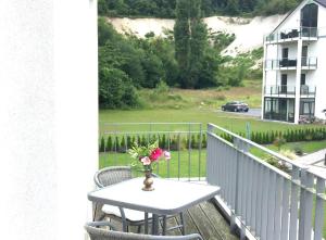 a table on a balcony with a vase of flowers at Ferienwohnung *Richi* in Sassnitz