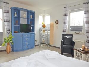 a bedroom with a blue cabinet and a bed at Villa Monika App 7 in Sassnitz