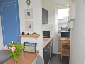 a kitchen with a table with a vase of flowers at Villa Monika App 7 in Sassnitz