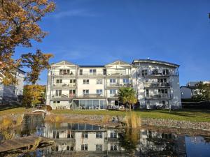 a large white building next to a body of water at Villa Nause-FeWo Buchenfreund mit Spa und Freizeit in Sassnitz