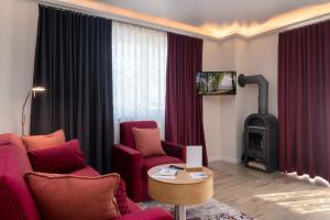 a living room with two chairs and a wood stove at Villa Nause-FeWo Buchenfreund mit Spa und Freizeit in Sassnitz