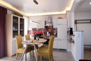 a kitchen with a table and chairs in a kitchen at Villa Nause-FeWo Buchenfreund mit Spa und Freizeit in Sassnitz
