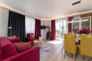 a living room with a pink couch and a table at Villa Nause-FeWo Buchenfreund mit Spa und Freizeit in Sassnitz +19 photos
