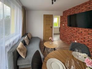 a living room with a couch and a brick wall at Apartament Bałandy 32 in Oświęcim
