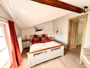 a bedroom with a bed with red pillows at Villa Seestern - Ferienhaus mit Meerblick in Sassnitz