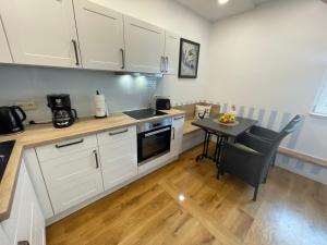 a kitchen with white cabinets and a small table at Villa Seestern - Ferienhaus mit Meerblick in Sassnitz