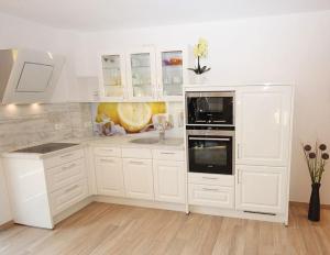 a white kitchen with white cabinets and a sink at Villa Amelie FeWo Seemoewe in Sassnitz