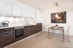 a kitchen with wooden cabinets and a table with chairs at Villa Friede Marie FeWo Ariane in Sassnitz