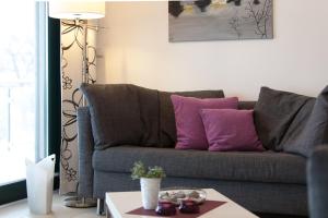 a living room with a couch with purple pillows at Villa Friede Marie FeWo Ariane in Sassnitz
