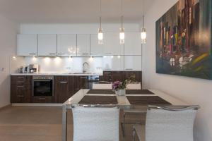a kitchen with white cabinets and a table with chairs at Villa Friede Marie FeWo Ariane in Sassnitz