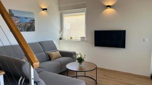 a living room with a couch and a tv at HvarLove Seaview Luxury in Hvar