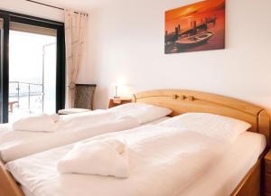 two white beds in a room with a window at Villa Friede-Marie, FeWo Meeresidyll in Sassnitz