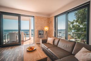 a living room with a couch and large windows at Villa Friede Marie FeWo Ostseeweitblick in Sassnitz