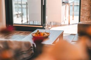 a bowl of fruit and two wine glasses on a table at Villa Friede Marie FeWo Ostseeweitblick in Sassnitz +20 photos