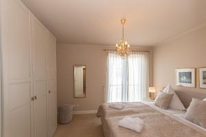 a bedroom with a bed and a chandelier at Villa Friede Marie FeWo Svea in Sassnitz