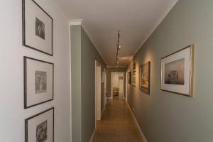 a hallway with framed pictures on the walls at Villa Friede Marie FeWo Svea in Sassnitz