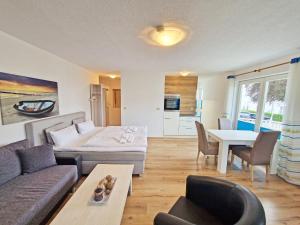 a living room with a couch and a bed and a table at Villa Monika Backbord 2 in Sassnitz