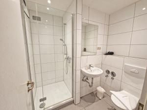 a bathroom with a shower and a toilet and a sink at Villa Monika Backbord 2 in Sassnitz