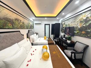 a hotel room with two beds and a table in it at Green Luxury Hanoi Hotel in Hanoi +184 photos