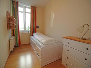 a bedroom with a bed and a dresser and a window at Villa Seeblick - Apartment 309 in Sassnitz