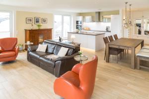 a living room with a leather couch and a table at Villa am Kreidebruch - Ostseeweitblick in Sassnitz