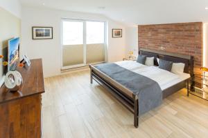 a bedroom with a large bed and a brick wall at Villa am Kreidebruch - Ostseeweitblick in Sassnitz