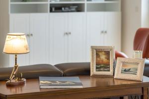 a table with two pictures and a lamp on it at Villa am Kreidebruch - Ostseeweitblick in Sassnitz
