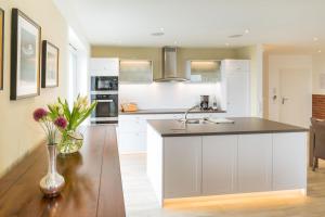 a kitchen with white cabinets and a vase with flowers at Villa am Kreidebruch - Ostseeweitblick in Sassnitz